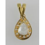 A yellow metal and diamond set pendant, centered with a pear-cut diamond, on an openwork mount.