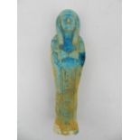 A Egyptian late dynastic shabti, semi glazed in turquoise. H.19cm