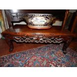 An early 20th century Chinese carved huali wood low table, having a simulated bamboo moulded top,