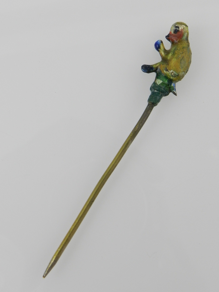 An unusual painted base metal tie pin, fashioned as a seated monkey.