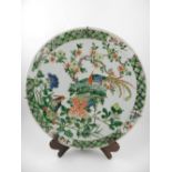 An early 20th century Canton porcelain wall charger, decorated in the famille verte pallet with
