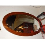 An Edwardian mahogany boxwood and ebony chequer line inlaid oval wall mirror.