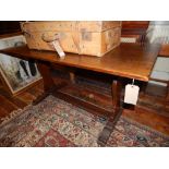 A 17th century style oak refectory dining table, having a rectangular top raised on shaped end