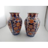 A pair of late 19th century Japanese Imari baluster vases, decorated with vignettes of flowers and