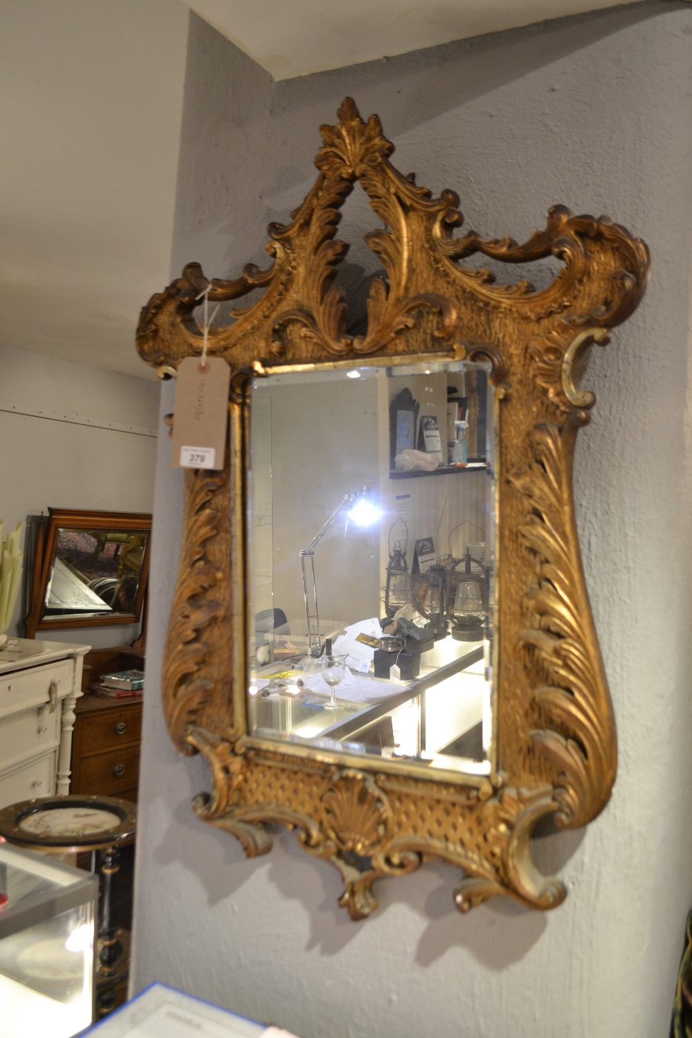 An 18th century Venetian style carved giltwood looking glass, having a relief moulded foliate frame,