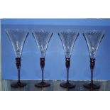 A set of four Venetian style clear and lilac glass wines with spiral moulded bowls on slender