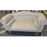 A small Victorian-style sofa, upholstered in natural striped fabric with button back,