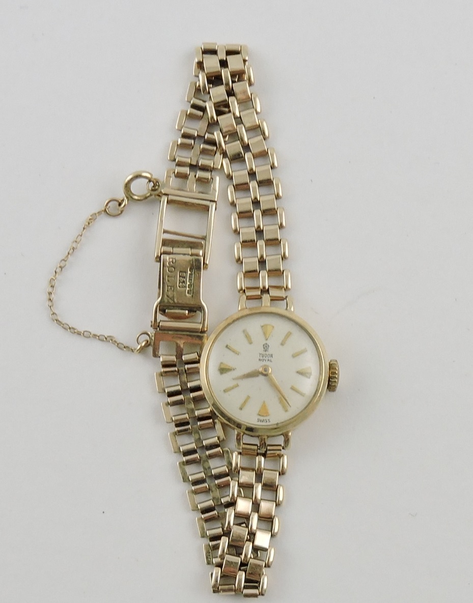 A 9ct Tudor ladies wristwatch with baton numerals on a 9ct gatelink strap.