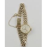 A 9ct Tudor ladies wristwatch with baton numerals on a 9ct gatelink strap.
