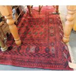 A Bokhara red ground carpet, woven rows of octagonal devices within a multi-border, 290cm x 200cm.