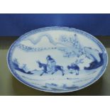 A Chinese 17th/18th Century blue and white saucer plate decorated with a nobleman riding a horse
