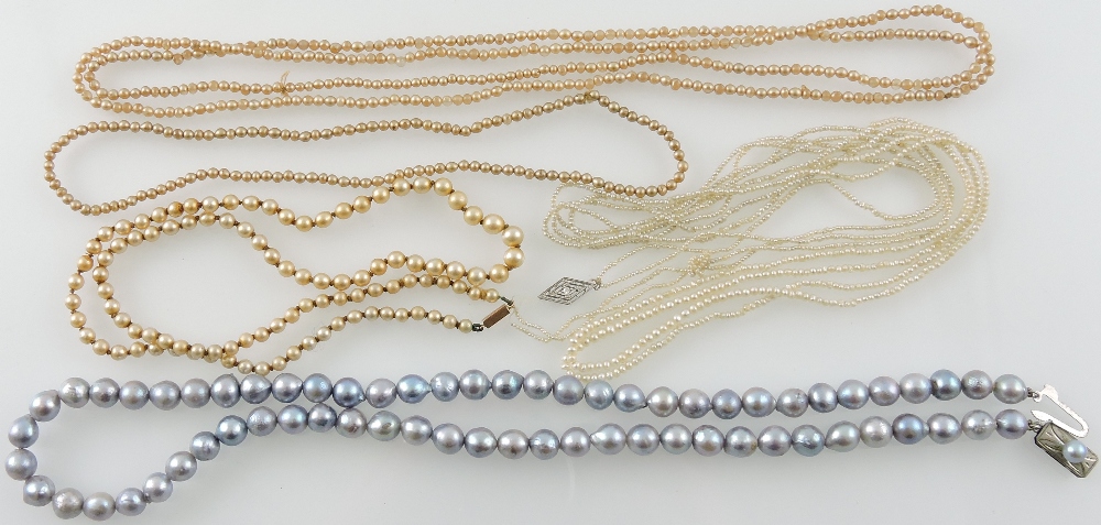 A grey baroque pearl necklace, L. 50cm, together with a four seed pearl necklaces, (5).