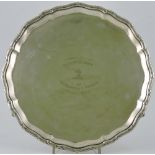 An Edwardian silver salver, Sheffield 1909, of scalloped circular form on three scroll feet,