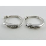 A pair of 9ct white gold and diamond half hoop earrings, total weight; approx. 0.