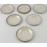 A set of six Egyptian silver card trays, of circular form with cast scroll rims, 25ozt.