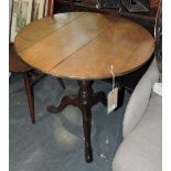 An early 19th Century oak tea table with circular tilt top on turned pillar and cabriole tripod.