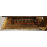 An early 20th Century shirvan brick red ground rug woven central panel of boteh within a wide