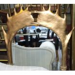 A gilded wall mirror, the frame in the form of antlers, with oval bevelled plated, H. 109cm.