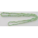 A graduated jade bead necklace, L. 78cm.