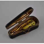 A limoges style novelty porcelain violin case, the gilt interior containing a miniature violin, L.