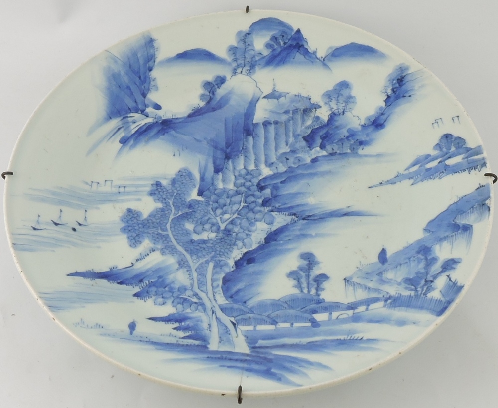 A late 19th century Chinese blue and white charger, decorated with an extensive landscape scene, D.