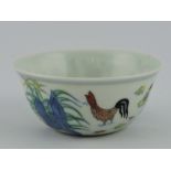 A doucai tea bowl, the exterior decorated with chickens and chicks, six character mark to base, D.