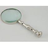 A chrome-plated table magnifier, with turned handle, L. 23cm.