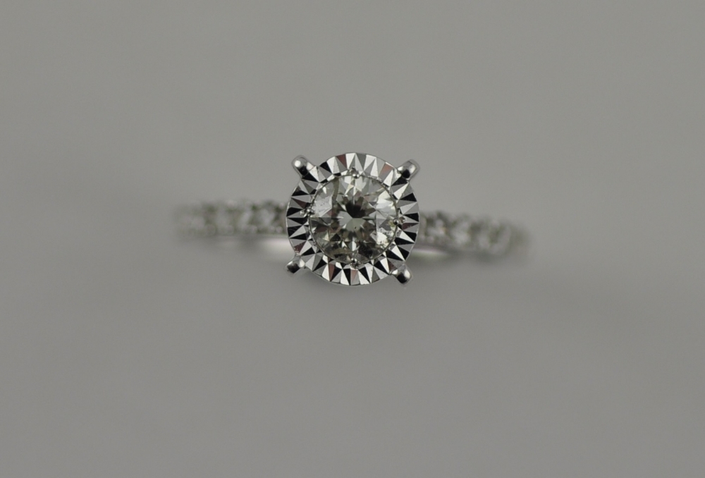 An 18ct white gold diamond solitaire with diamond set shoulders, total 0.