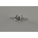 An 18ct white gold diamond solitaire with diamond set shoulders, total 0.