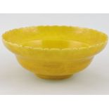An Imperial yellow dish, with scalloped edge and incised decoration of dragons to the exterior,