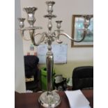 A pair of silver plated five branch candelabras on circular bases.