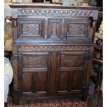 A 17th Century style carved oak duodarn, upper section enclosed by two panelled doors on style feet,