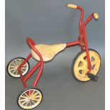 A late 20th century tin-plate and tubular steel child's tricycle, painted yellow and red,