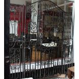 An impressive Victorian three section wrought iron gate of arched form decorated with scrollwork