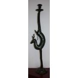 A bronzed metal candlestick modelled as a stylised stag, the sconce supported by the hind quarters,