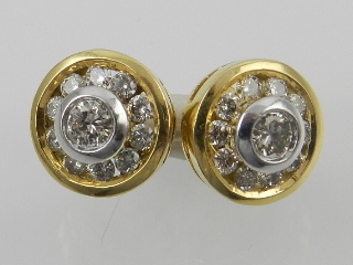 A pair of yellow metal and diamond circular ear studs, the central stones of approx. 0.