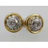 A pair of yellow metal and diamond circular ear studs, the central stones of approx. 0.