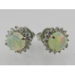 A pair of white metal, diamond, and opal cluster ear studs.