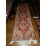 A Keshan style runner, having a triple medallion on a red and cream ground. L.210cm W.70cm