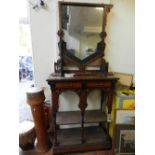 A late 19th century North African hardwood side cabinet having a contained mirror crowned by carved