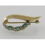 A 9 carat yellow gold, diamond, and emerald set brooch,