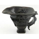 A Chinese carved horn libation cup, having applied dogs of Fo. H.