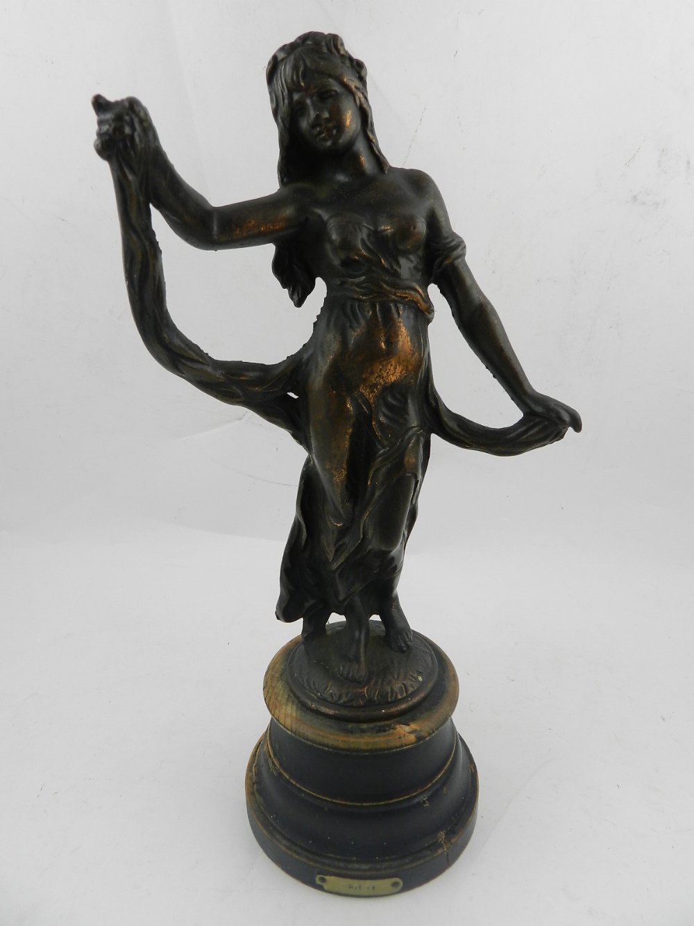 In the Art Nouveau style, a bronze bust of a female nude, raised on a circular base.