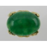 An unusual yellow, diamond, and jade ring, the green cabouchon jade raised in a leaf-shaped mount,