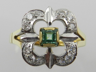 An 18 carat yellow gold, diamond, and emerald set ring of quatrefoil form.