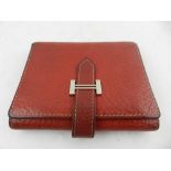 A red leather Hermes wallet.