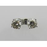 A pair of 14ct white gold solitaire diamond ear studs, total weight 1.08ct.