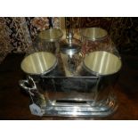 A silver plated wine cooler, having four wine holders and handles to side. H. 24cm, L.30cm, D.