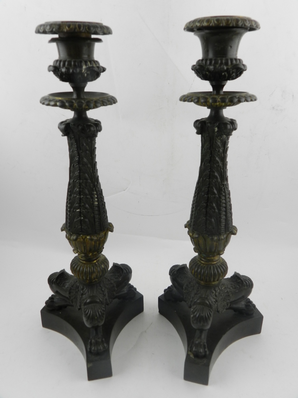 A pair of 19th century bronze candlesticks, in the form of three paw tri-form feet. H.