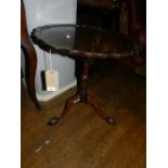A 19th century mahogany pie-crust top tilt-top table, raised on three ball and claw tripod legs,